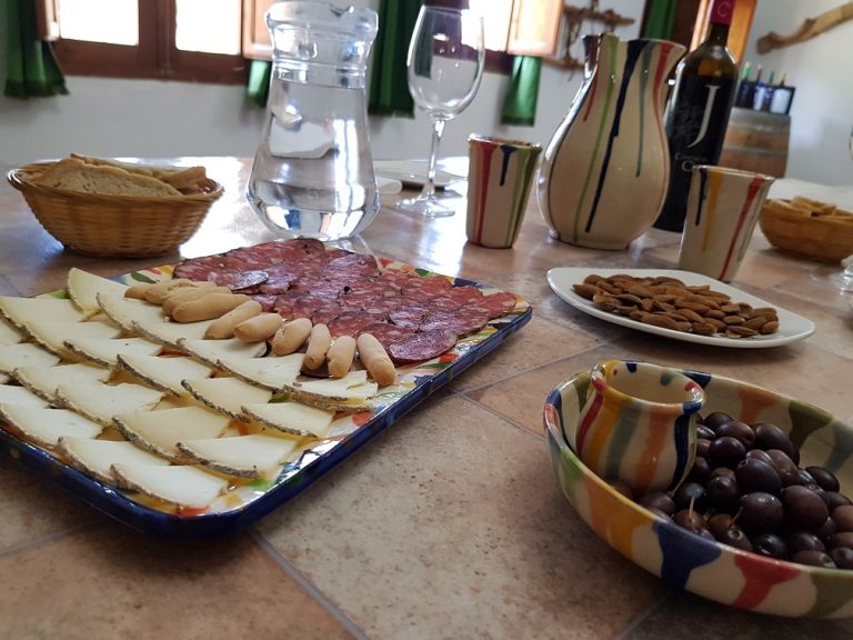 Tabla de quesos artesanales, embutidos y pan tradicional maridados con vinos ecológicos en una cata en La Alpujarra.